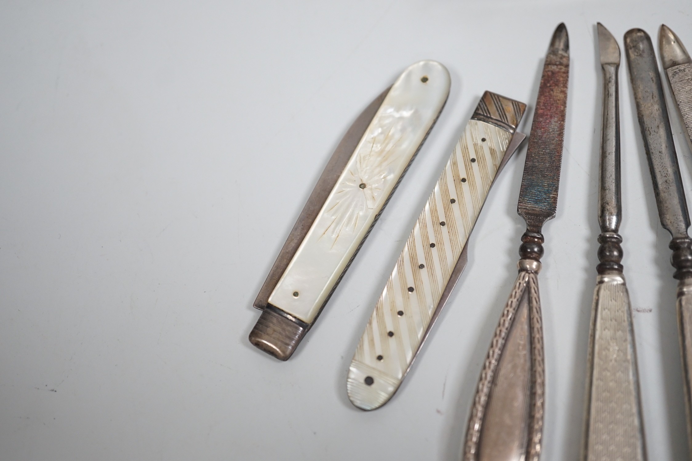 A small group of assorted manicure items and a leather travelling case containing a matched silver and mother of pearl travelling knife and fork.